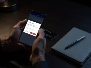 Usuario revisando en su teléfono móvil una alerta de transferencia bancaria realizada por error.