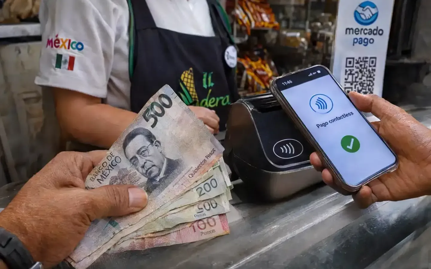 Mano sosteniendo billetes de pesos mexicanos junto a un teléfono inteligente realizando un pago digital.